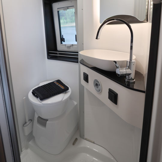 Modernes Badezimmer mit Dusche und WC im Pössl Campervan von Fox Camper – komfortabel reisen und unabhängig campen.