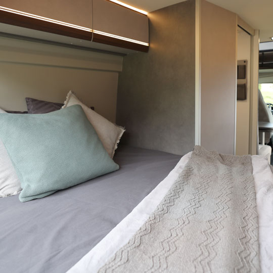 Komfortabler Schlafbereich mit Doppelbett im Pössl Campervan von Fox Camper – entspannter und erholsamer Schlaf wie zuhause.